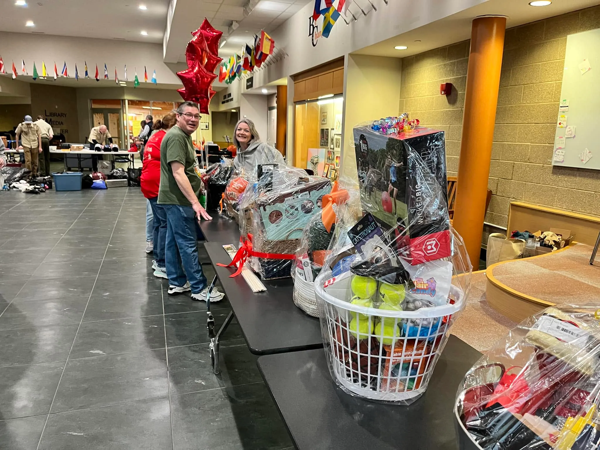 Shoppers looking over gift baskets at the silent auction