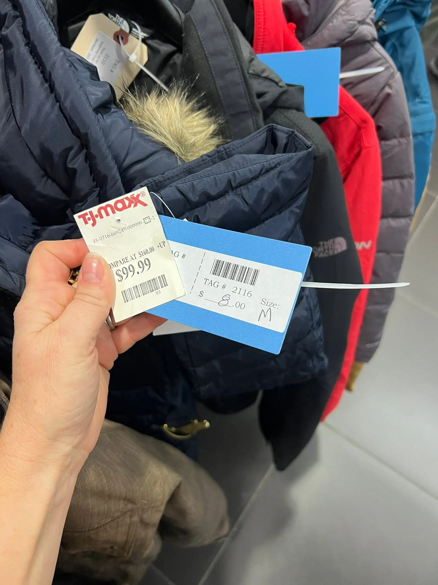 A jacket still carrying its $99.99 store tag, next to its $8 Sportsmart price tag